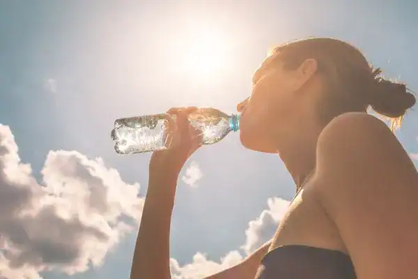 Hydration: The Secret Ingredient for a Toned Stomach and Enhanced Fitness 3 Image of woman drinking water to hydrate Harwich after run.